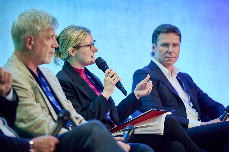 A panel discussion taking place on stage at the Fleets in Charge Conference. A female panellist addresses a question in front of a blue stage backdrop