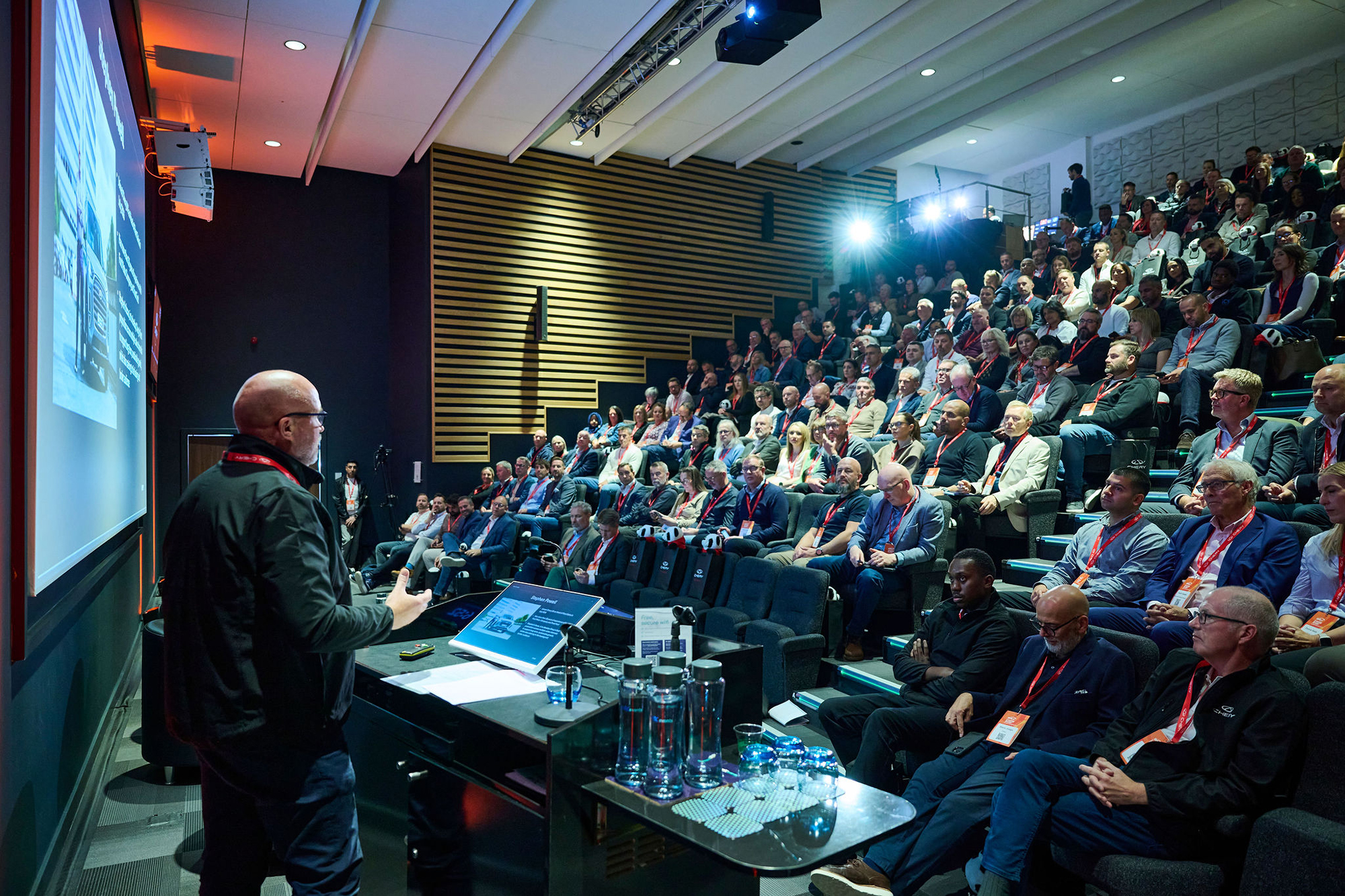 A view of a speaker on the left and then a whole auditorium of people sitting in the audience at the BVRLA Leasing Broker Conference 2026