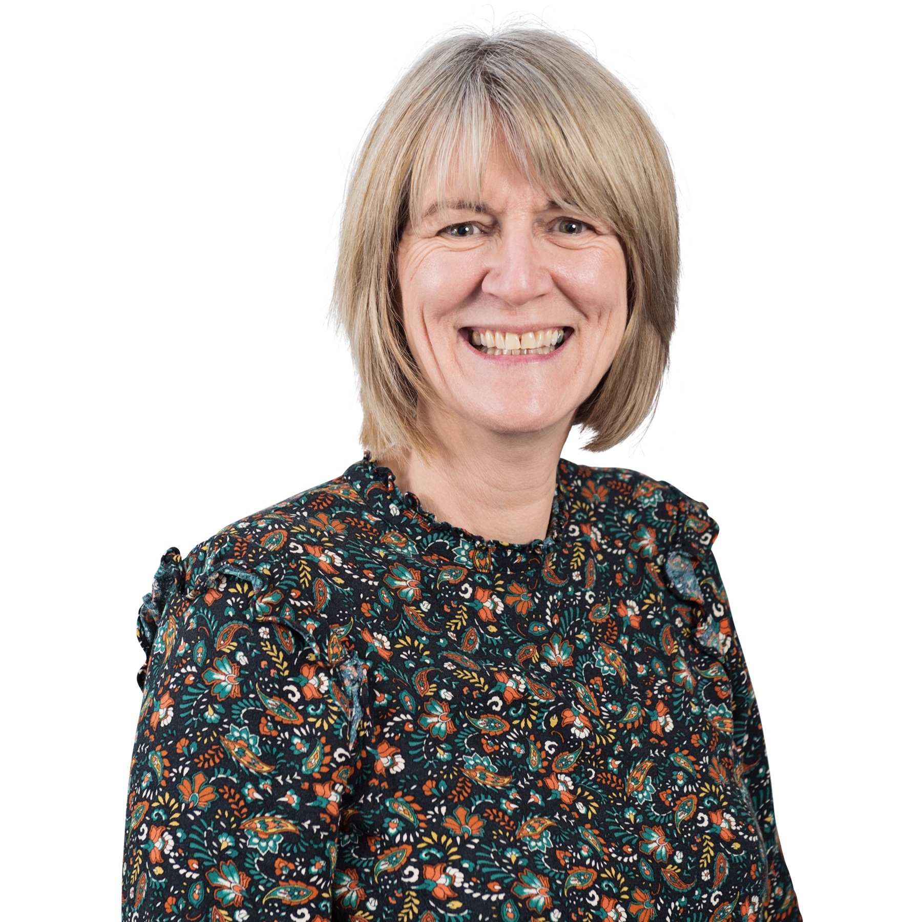 Headshot of Michelle Tugwell on a white background. Toby is a dark top with a floral pattern