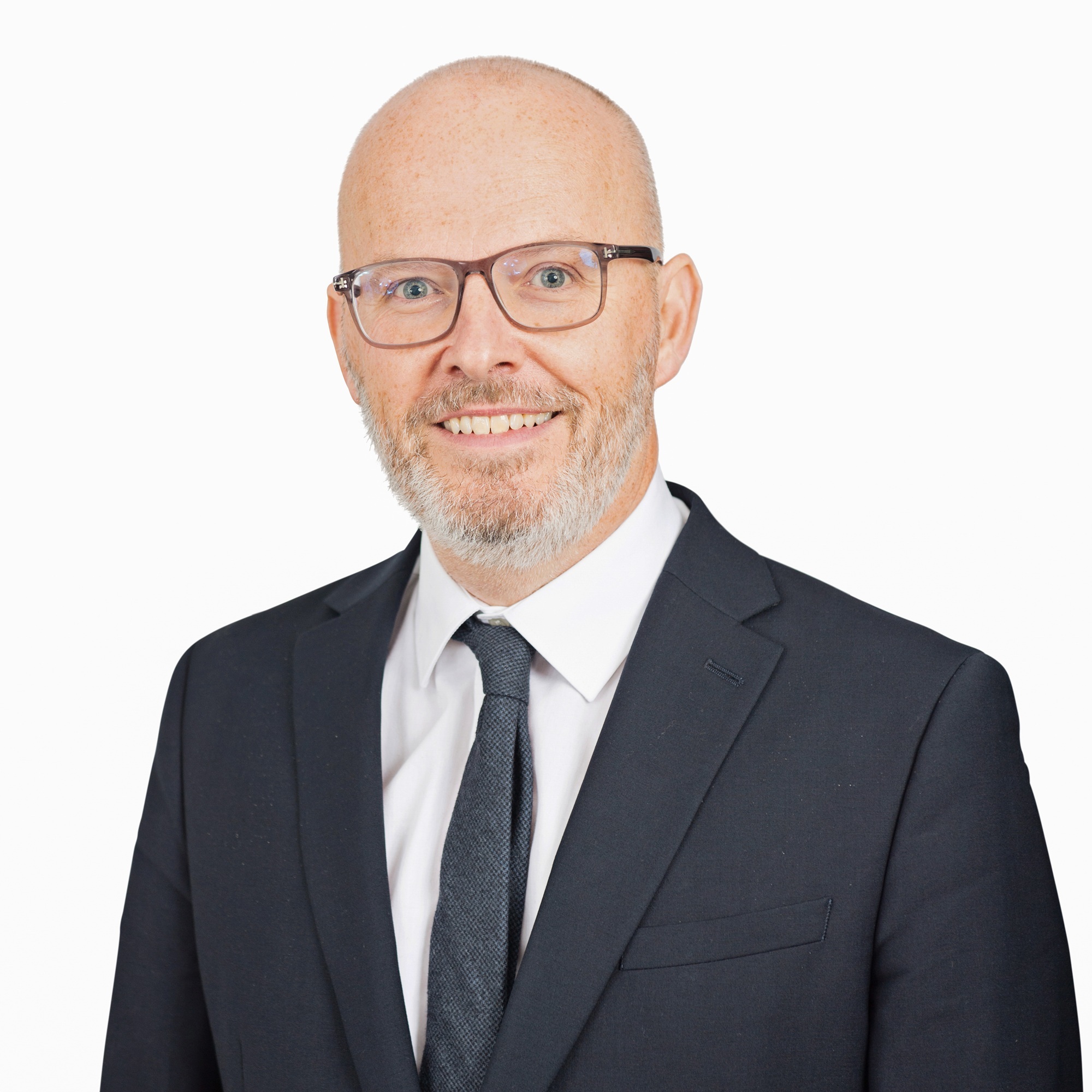 Headshot of Toby Poston on a white background. Toby is wearing glasses, a smart white shirt and black BVRLA pullover