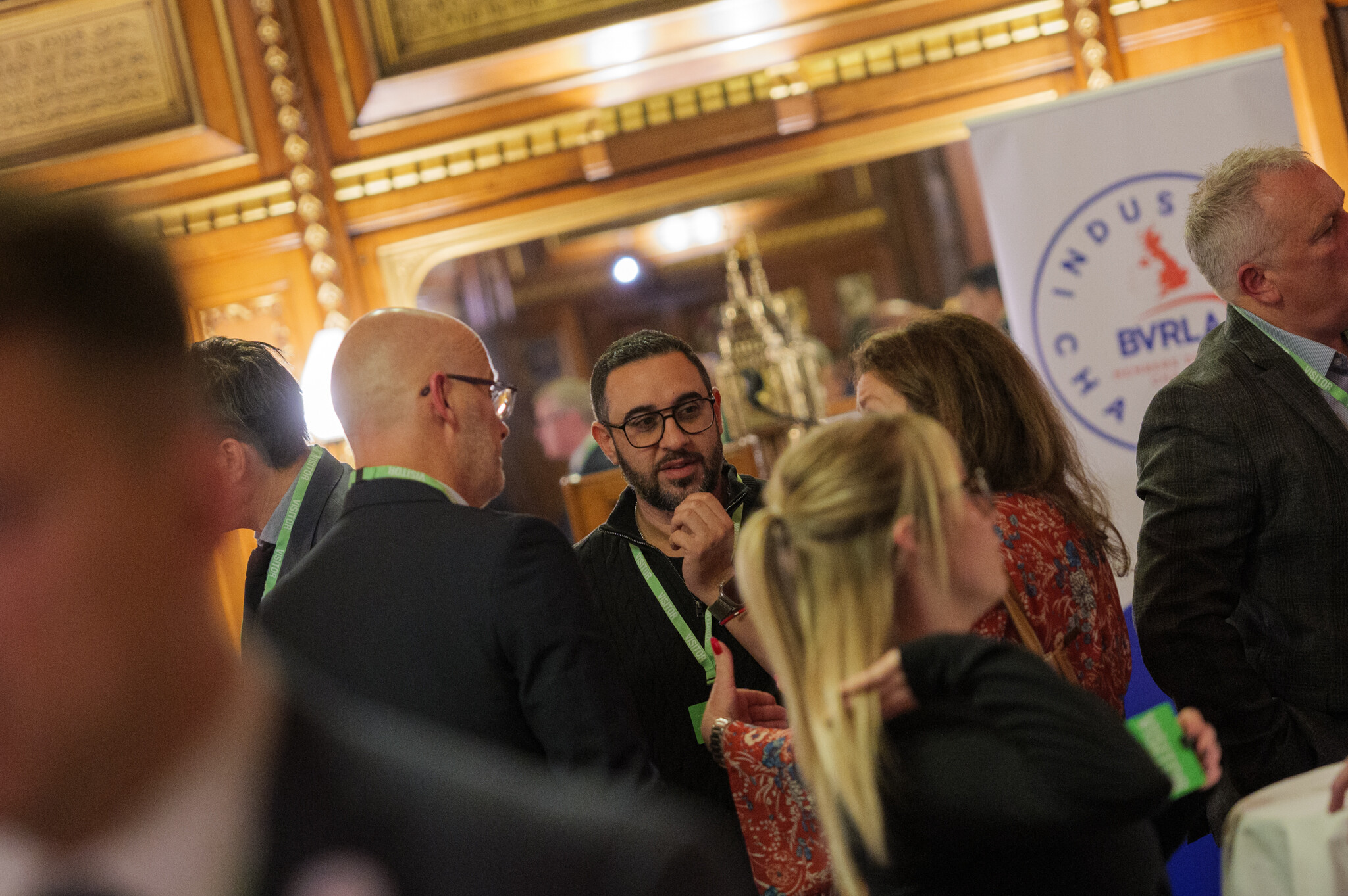 Image shows a host of industry professionals networking at part of an evening reception. Setting is a wood-panelled room in the Houses of Parliament